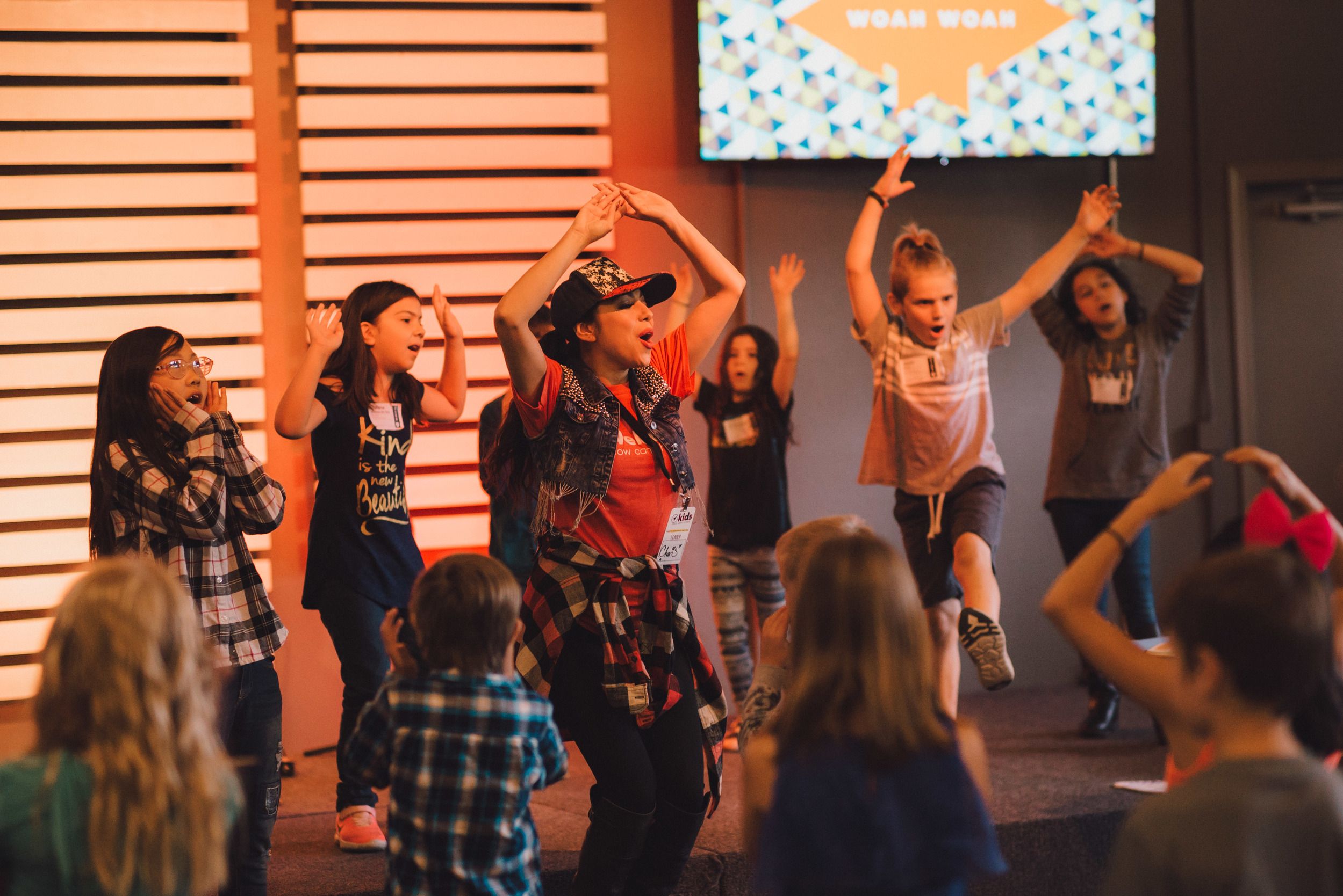 Elementary children singing and dancing on a stage